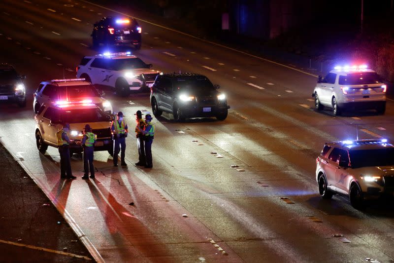 Washington State Patrol investigates the scene where two people in a group of protesters were stuck by a car on Interstate 5, in Seattle