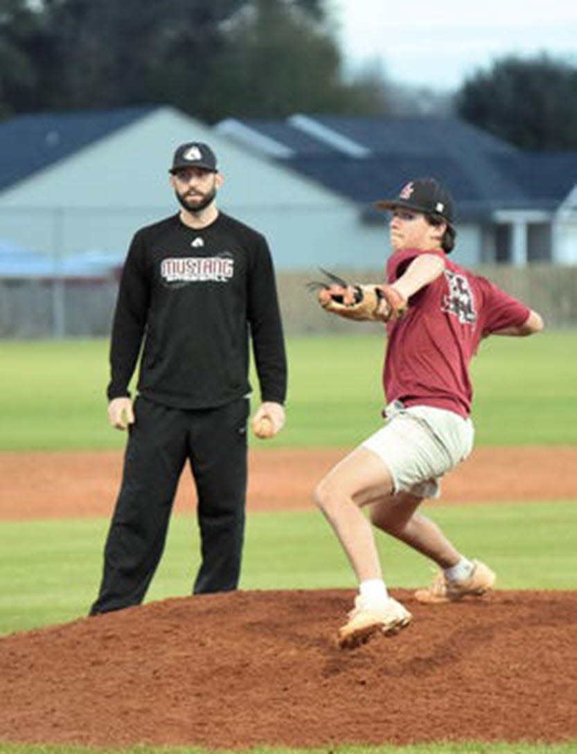 South Effingham High School pitching coach Jesse Osborne, left, works with Dru Futch.