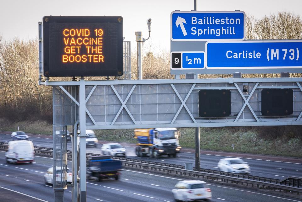 Information signs above the M8 motorway in Glasgow encourage people to get a Covid booster jab (PA)