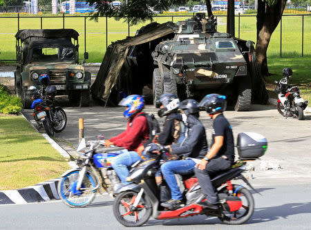 Motorists drive past an Armoured Personnel Carrier (APC) parked near the venue of the 50th ASEAN Foreign Ministers meeting in Pasay city, metro Manila, Philippines August 4, 2017. REUTERS/Romeo Ranoco