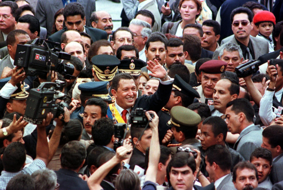 FILE - In this Feb. 2, 1999 file photo, newly sworn-in President Hugo Chavez greets supporters during a parade through the streets of downtown Caracas, Venezuela. Amid the political turmoil roiling Venezuela it’s easy to overlook this milestone: the 20th anniversary on Saturday, Feb. 2, 2019, of Chavez’s Bolivarian revolution, when he took office with a fiery anti-imperialist rhetoric that would inspire leaders across Latin America and reshape the region’s relations with Washington. (AP Photo/Rodolfo Benitez, File)