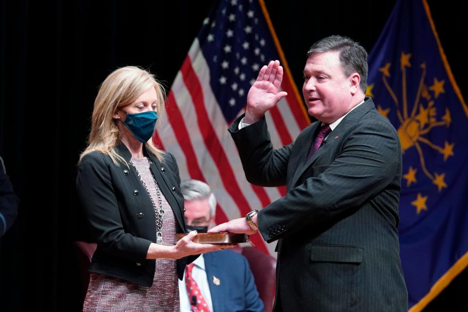 Todd Rokita is sworn in as Indiana's attorney general by Chief Justice Loretta H. Rush on a bible held by his wife, Kathy, during an inaugural ceremony at the Indiana State Museum, Monday, Jan. 11, 2021, in Indianapolis. (AP Photo/Darron Cummings)