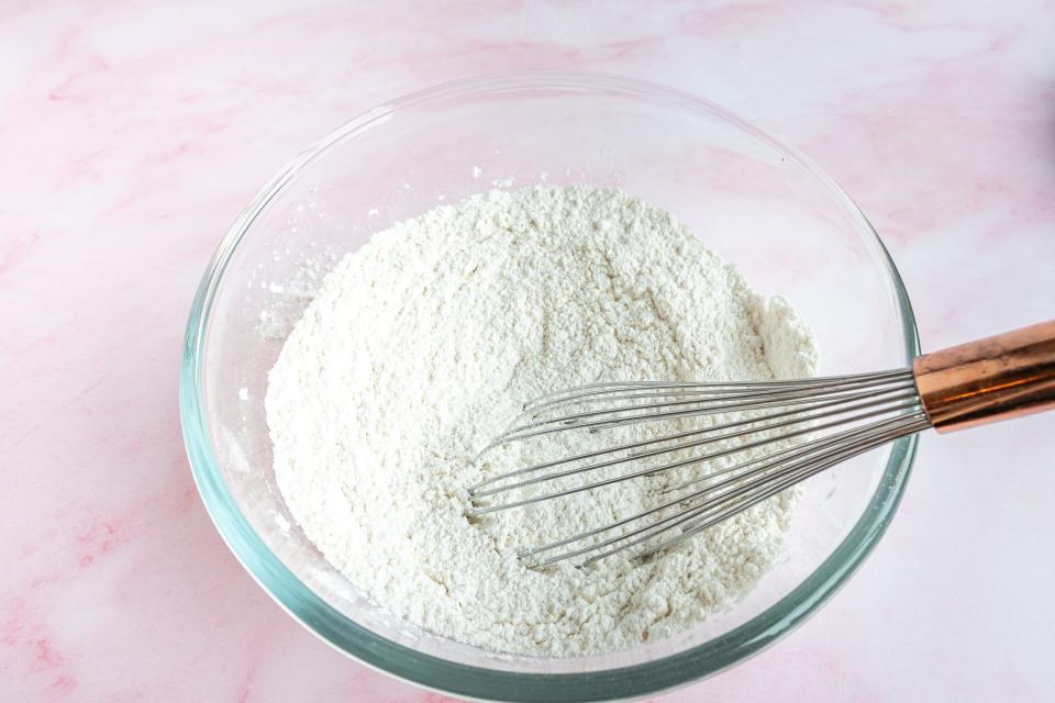 whisking flour in a glass bowl