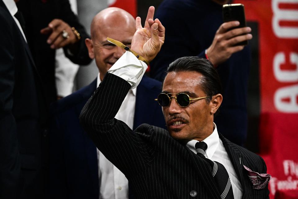 salt bae doing his signature move while wearing a suit