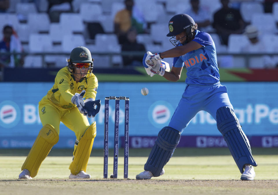 India's Harmanpreet Kaur swings at the ball while Australia's Alyssa Healy watches on during the Women's T20 World Cup semi final cricket match in Cape Town, South Africa, Thursday Feb. 23, 2023. (AP Photo/Halden Krog)
