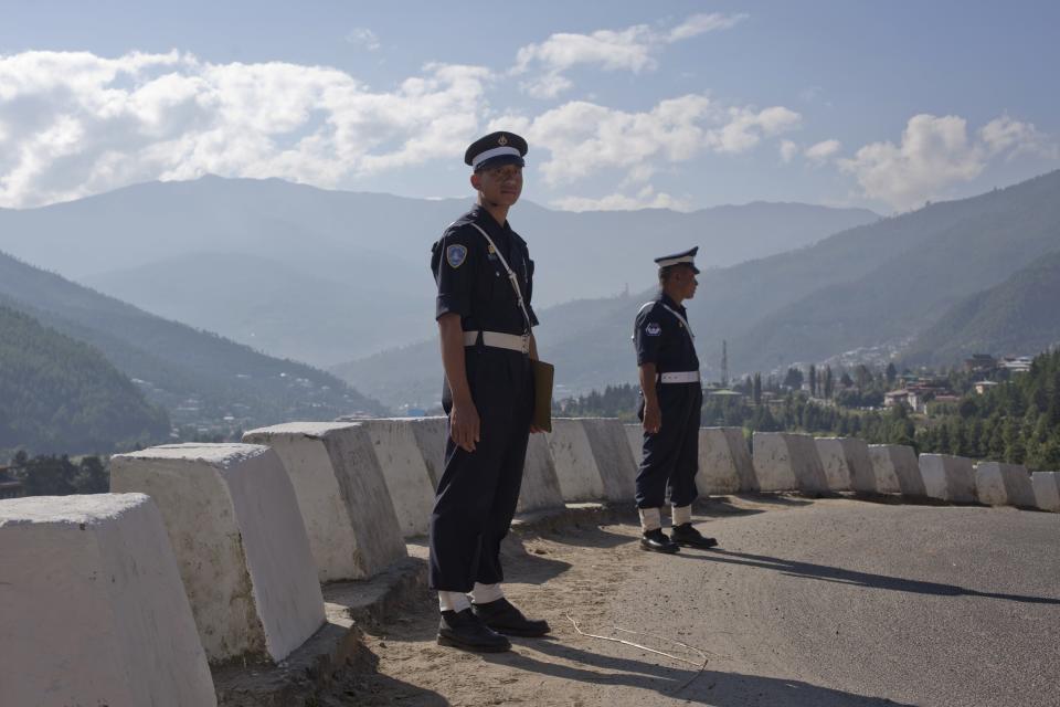 Policemen stand guard near a hilltop roundabout in Bhutan's capital Thimphu