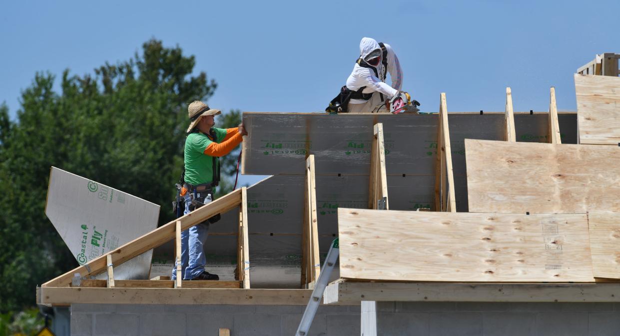 Construction workers install plywood sheets on the roof of a new home in Lakewood Ranch. 