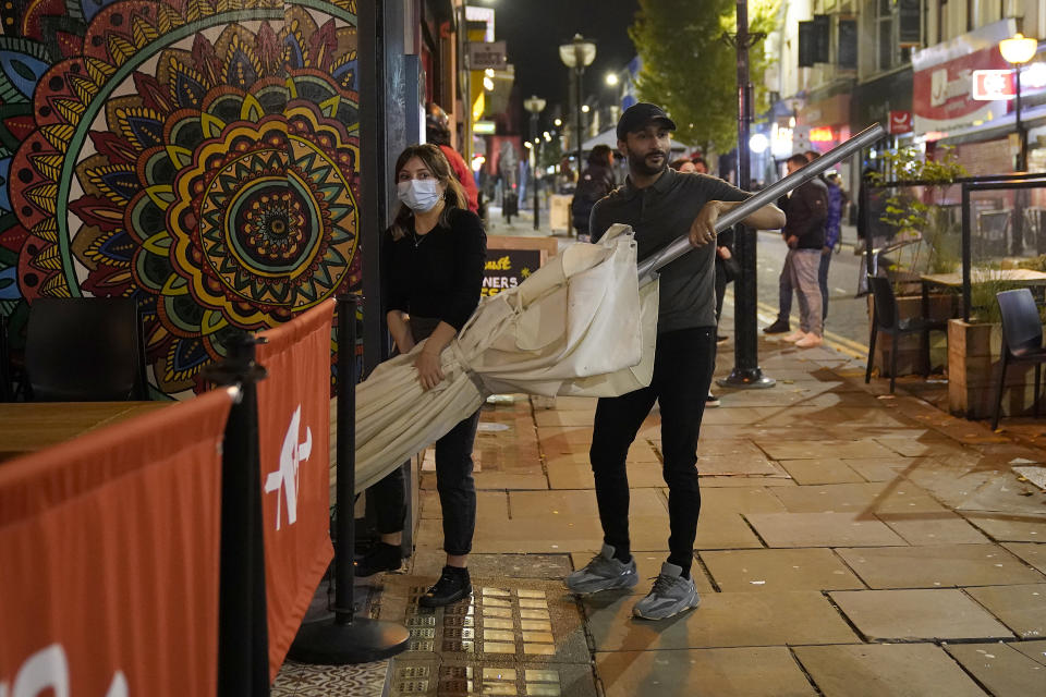 LIVERPOOL, ENGLAND - OCTOBER 13: Restaurant staff clear away their street furniture in the city centre on the eve of lockdown restrictions on October 13, 2020 in Liverpool, England. As the British government announced a new three-tier system for ranking the severity of local COVID-19 spread, the Liverpool City Region was immediately ranked "very high" risk, forcing its pubs, bars, gyms and leisure centres to close from Wednesday. (Photo by Christopher Furlong/Getty Images)