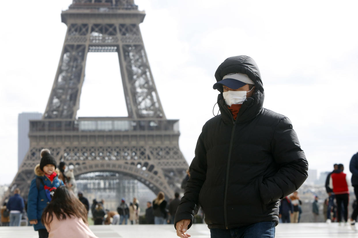 People wear a face mask on the Trocadero esplanade in front of the Eiffel Tower in Paris, France, March 3, 2020, as France confirmed a more than 200 persons infected with coronavirus, on February 29 in France. (Photo by Mehdi Taamallah/NurPhoto via Getty Images)