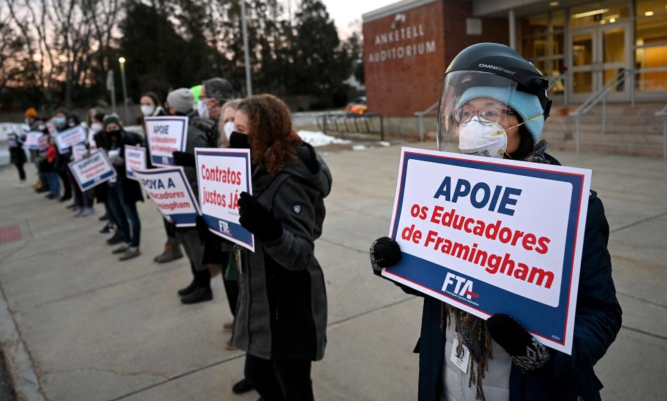 Aiping Dong, a Mandarin Chinese teacher, holds a sign as students arrive at Framingham High School during a teacher standout designed to call attention to an expired contract, Jan. 19, 2021.