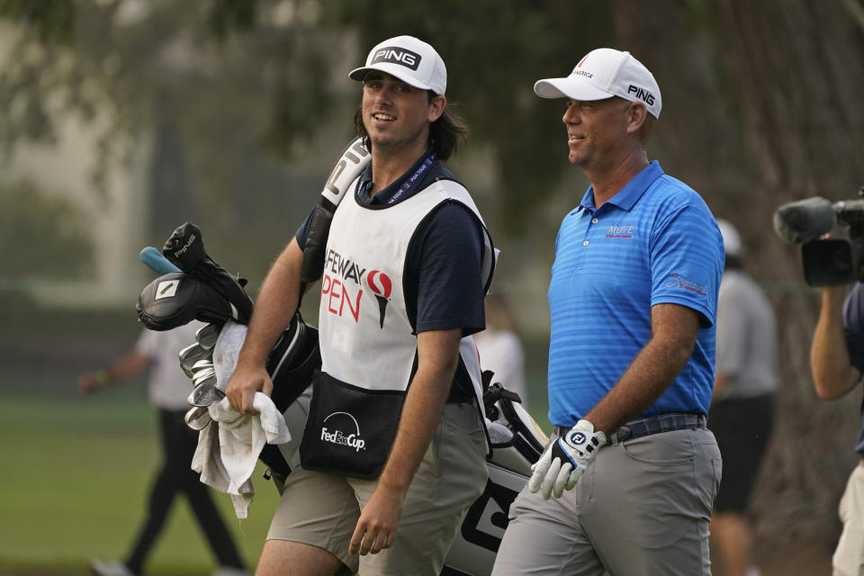 FILE - Stewart Cink, right, walks with his caddie and son, Reagan Cink, down the 18th fairway of the Silverado Resort North Course during the final round of the Safeway Open PGA golf tournament in Napa, Calif., in this Sunday, Sept. 13, 2020, file photo. Cink revealed Wednesday, Nov. 18, he and his wife had the coronavirus in March and didn't realize it until antibody tests were positive in June. (AP Photo/Eric Risberg, File)