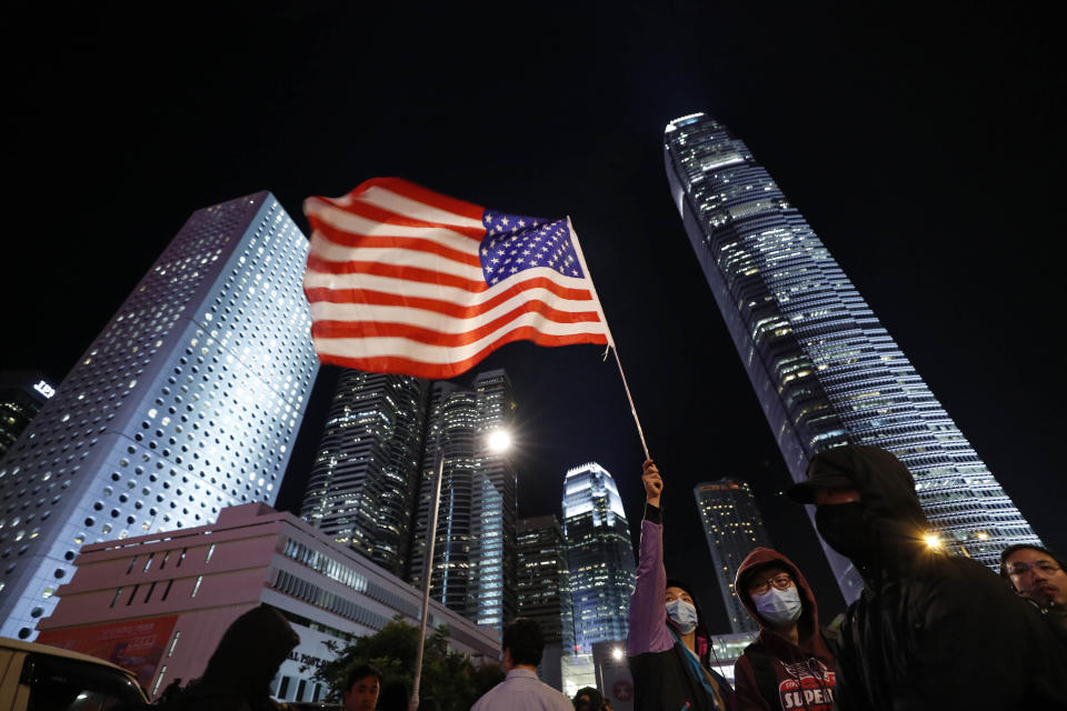 A protestor holds high a U.S. flag in Hong Kong, Thursday, Nov. 28, 2019. China reacted furiously Thursday to President Donald Trump’s signing of bills on Hong Kong human rights, summoning the U.S. ambassador to strongly protest and warning the move would undermine cooperation with Washington. Hong Kong, a former British colony that was granted special autonomy when China took control in 1997, has been rocked by six months of sometimes violent pro-democracy demonstrations. (AP Photo/Vincent Thian)