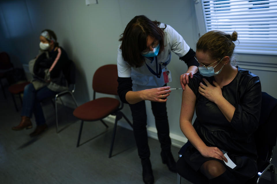 A nurse administrates a Pfizer/Biontech COVID-19 vaccine to a health care worker at the MontLegia CHC hospital in Liege, Belgium, Wednesday, Jan. 27, 2021. (AP Photo/Francisco Seco)