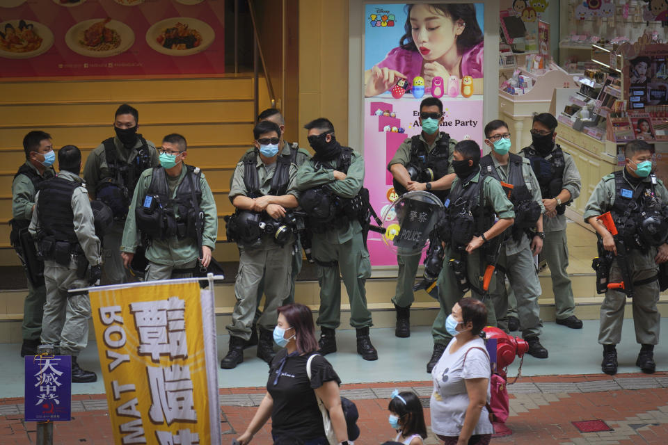 Police stand guard in Causeway Bay before the annual handover march in Hong Kong, Wednesday, July. 1, 2020. Hong Kong marked the 23rd anniversary of its handover to China in 1997, and just one day after China enacted a national security law that cracks down on protests in the territory. (AP Photo/Vincent Yu)