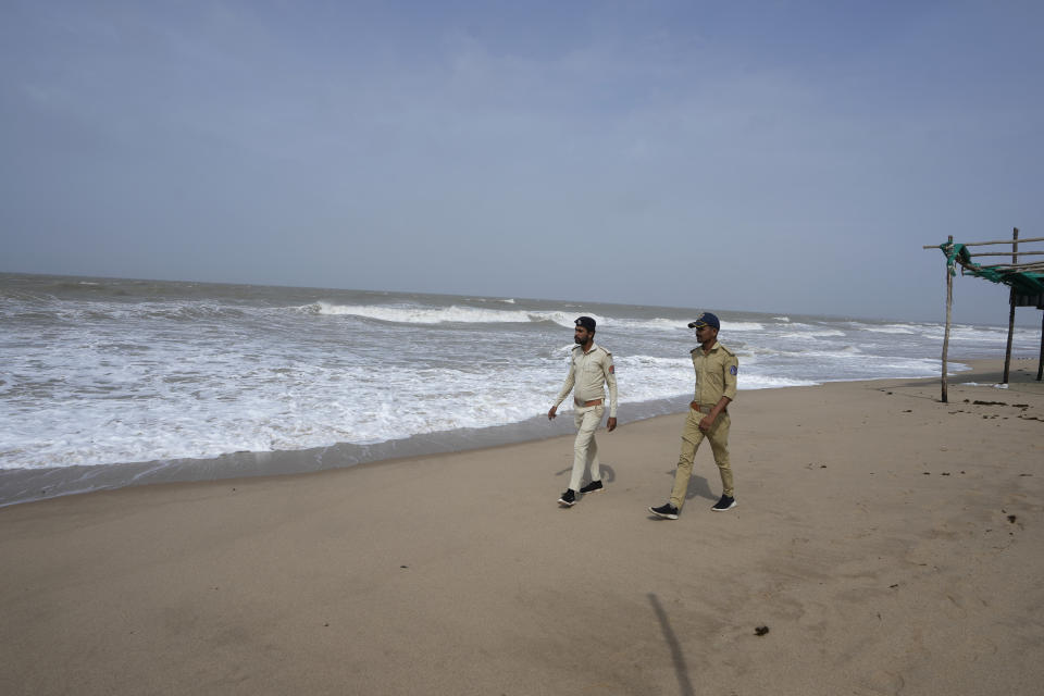 Policemen walk on a deserted beach on the Arabia Sea coast at Mandvi in Kutch district of Gujarat state, India, Wednesday, June 14, 2023. With Cyclone Biparjoy expected to make landfall Thursday evening, coastal regions of India and Pakistan are on high alert. (AP Photo/Ajit Solanki)