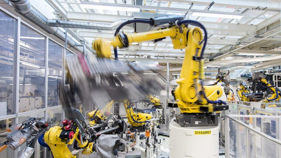 In der deutschen Industrie scheint es wieder aufwärts zu gehen: Industrieroboter schweißen in einer Volkswagen Autofabrik Teile an.