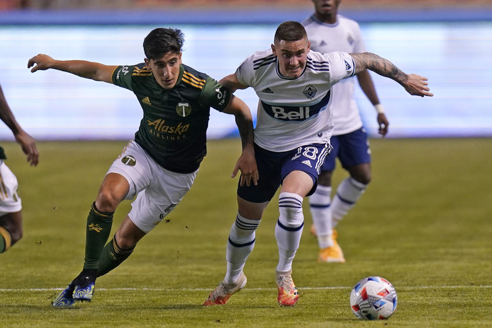 Vancouver Whitecaps defender Jake Nerwinski (28) and Portland Timbers defender Claudio Bravo (5) battle for the ball in the first half during an MLS soccer game Sunday, April 18, 2021, in Sandy, Utah. (AP Photo/Rick Bowmer)