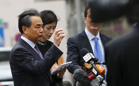 Chinese Foreign Minister Wang Yi (L) talks to journalists outside Palais Coburg, the venue for nuclear talks in Vienna, Austria, July 6, 2015. REUTERS/Leonhard Foeger