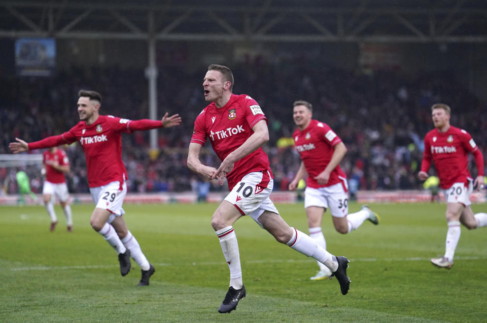 Wrexham's Paul Mullin, center, celebrates scoring their side's second goal of the game during the National League soccer match between Wrexham and Boreham Wood at The Racecourse Ground, in Wrexham, Wales, Saturday April 22, 2023. (Martin Rickett/PA via AP)