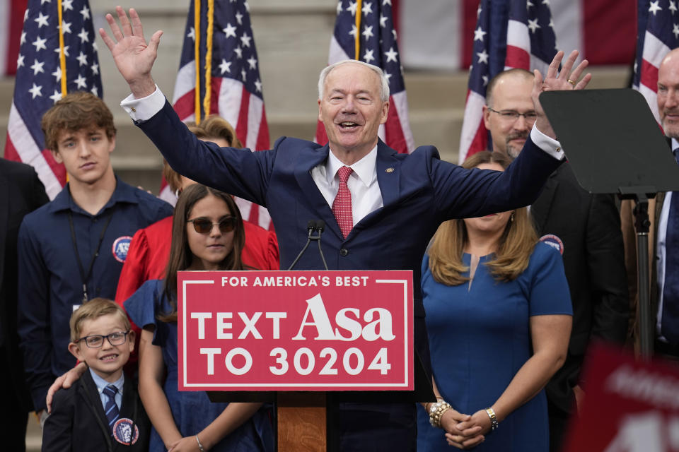 Former Arkansas Gov. Asa Hutchinson is surrounded by family members after formally announcing his Republican campaign for president, Wednesday, April 26, 2023, in Bentonville, Ark. (AP Photo/Sue Ogrocki)