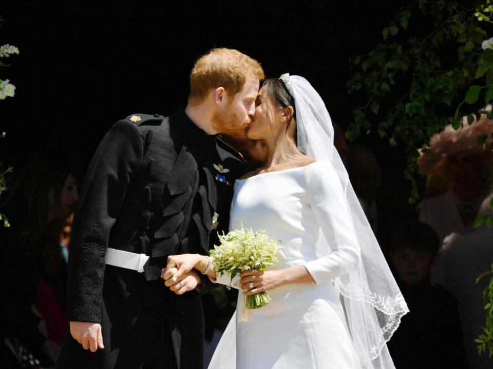 The Duke and Duchess of Sussex kiss on the steps of St George’s Chapel after their wedding (WPA Pool/Getty)