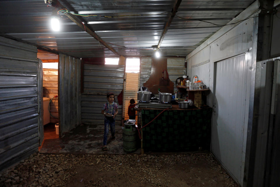 Children of Abu Rustom, founder of a Syrian refugee folklore troupe, prepare to join the family table at the Al-Zaatari refugee camp June 1.