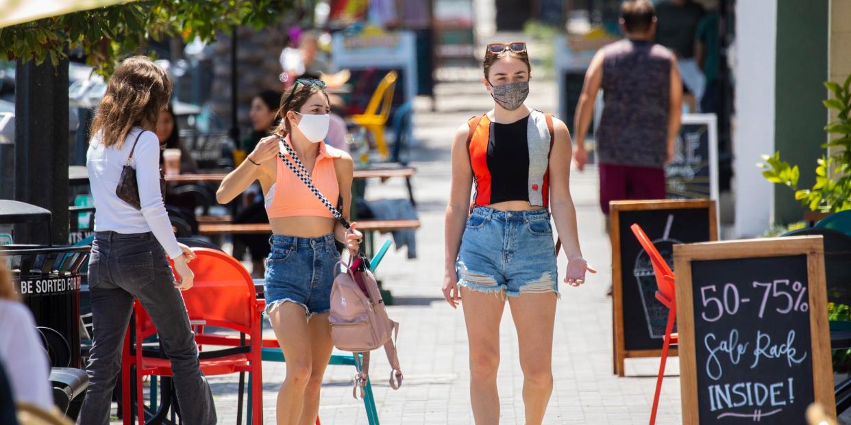 Two masked women walk along S. Catalina Avenue in the Riviera Village shopping area of Redondo Beach, CA.