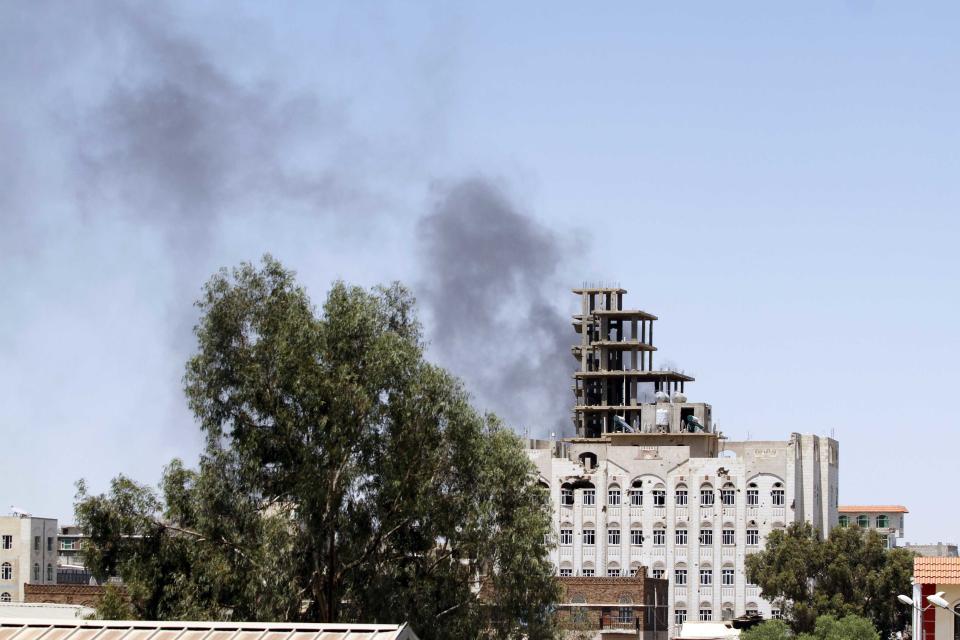 Smoke rises from the main gate of the army's first armoured division , which is under attack from Shi'ite Houthi militants, in Sanaa September 21, 2014. Shi'ite Houthi rebels and government forces fought for a fourth straight day in the Yemeni capital, residents said, despite the announcement of a U.N.-brokered agreement due to be signed later on Sunday. (REUTERS/Mohamed al-Sayaghi)