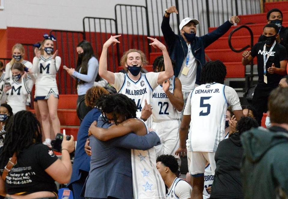 Members of the Millbrook basketball team and staff including Redford Dunton (center, #14) celebrate their win over Ardrey Kell in the boys 4A NCHSAA championship game at Wheatmore High School in Trinity, NC on Saturday, March 6, 2021. Millbrook defeated Ardrey Kell 67-65 in overtime.