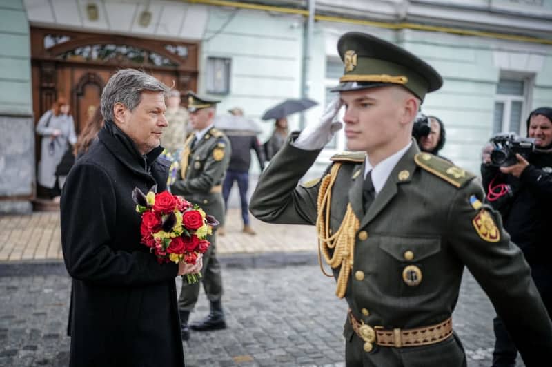 Robert Habeck (L), Germany's Minister for Economic Affairs and Climate Protection, lays flowers at the memorial wall for the soldiers who died in the war. Kay Nietfeld/dpa