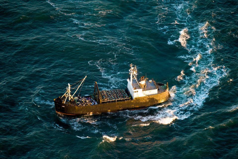 A crabbing vessel turns below a U.S. Coast Guard flyover inspection of crabbing ships along the Washington and Oregon coasts near Astoria, Ore., on Jan. 1, 2016. Oregon crab fishermen may soon face an indefinite extension of rules that for three seasons have restricted the number of pots allowed in the water to reduce the risk of whales and sea turtles getting entangled in fishing gear. (Joshua Bessex/The Astorian via AP, File)