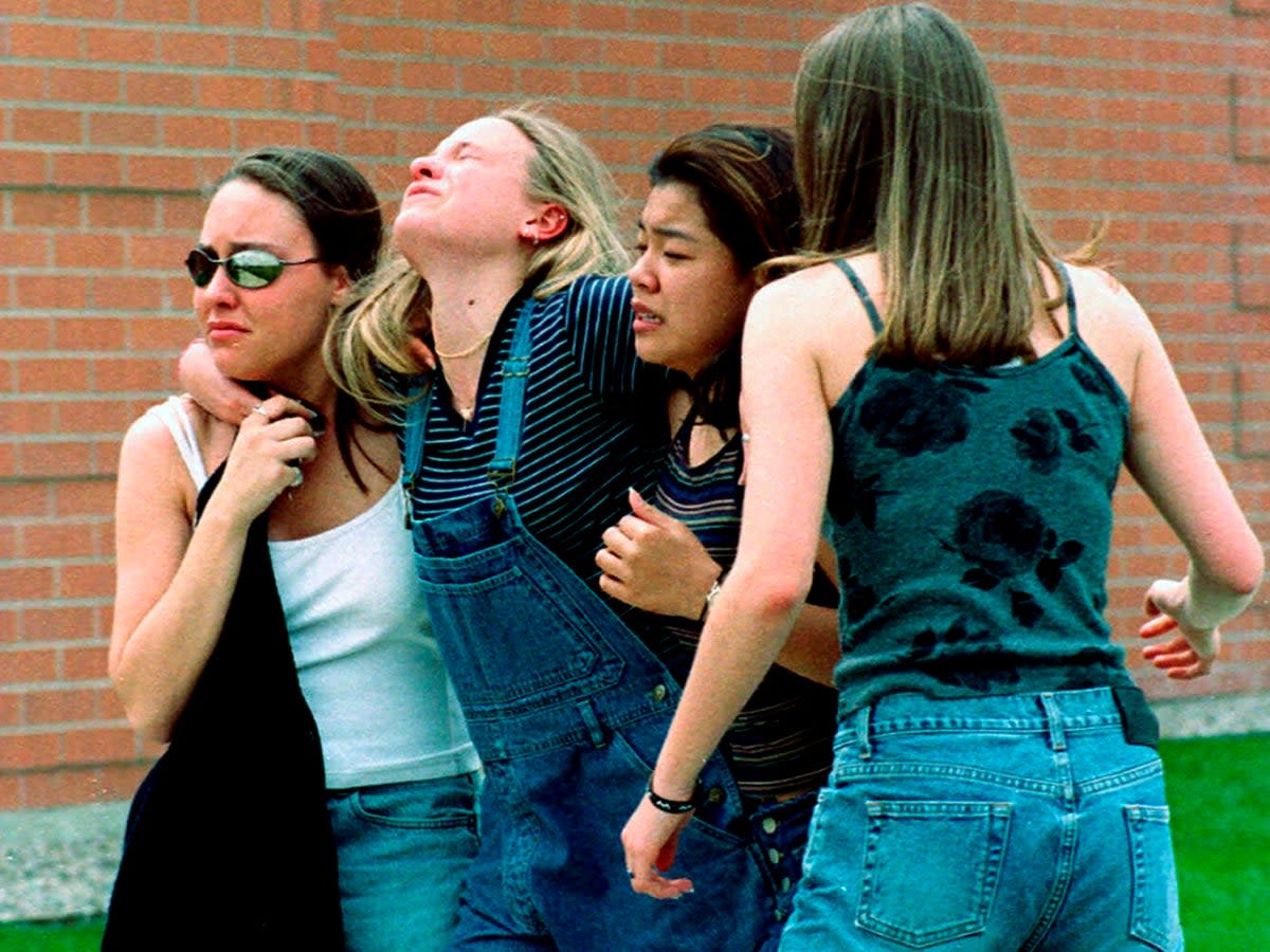 Young women head to a library near Columbine High School where students and faculty members were evacuated during the 1999 shooting (AP)