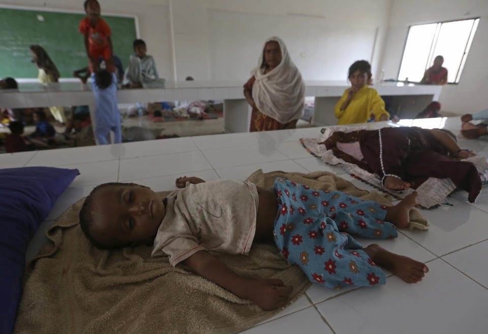 Displaced families take refuge in a government college building after fleeing their flood-hit homes, in Karachi, Pakistan, Monday, Aug. 29, 2022. International aid was reaching Pakistan on Monday, as the military and volunteers desperately tried to evacuate many thousands stranded by widespread flooding driven by "monster monsoons" that have claimed more than 1,000 lives this summer. (AP Photo/Fareed Khan)