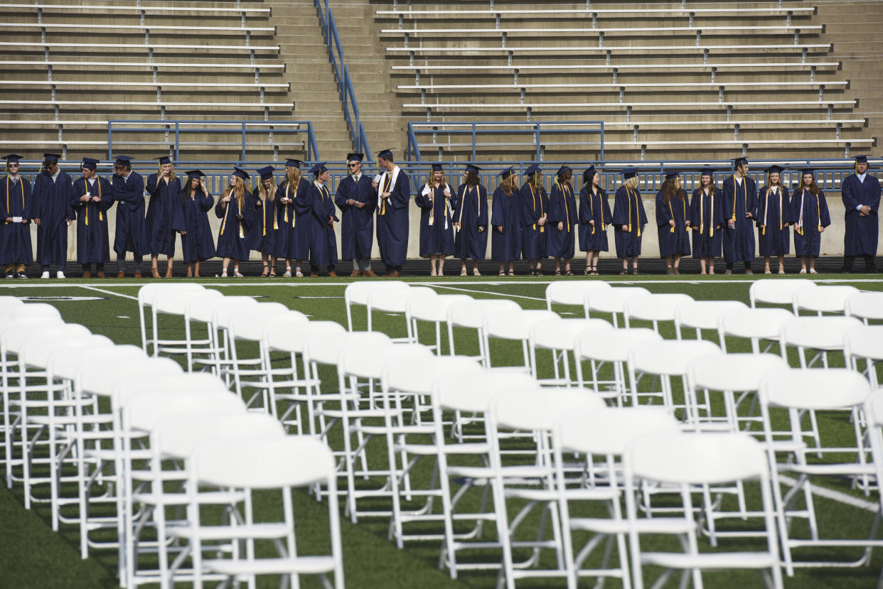 FILE - Graduates wait for the start of the St. Joseph High School Class of 2021 commencement ceremony, Sunday, June 6, 2021, in St. Joseph, Mich. High school graduation rates dipped in at least 20 states after the first full school year disrupted by the pandemic, according to a new analysis by Chalkbeat. (Don Campbell/The Herald-Palladium via AP, File)