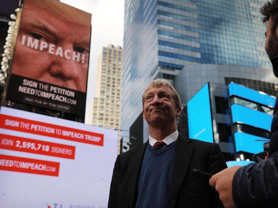 Tom Steyer stands in front of one of the billboards he has funded in Times Square calling for the impeachment of President Donald Trump (Spencer Platt/Getty Images)