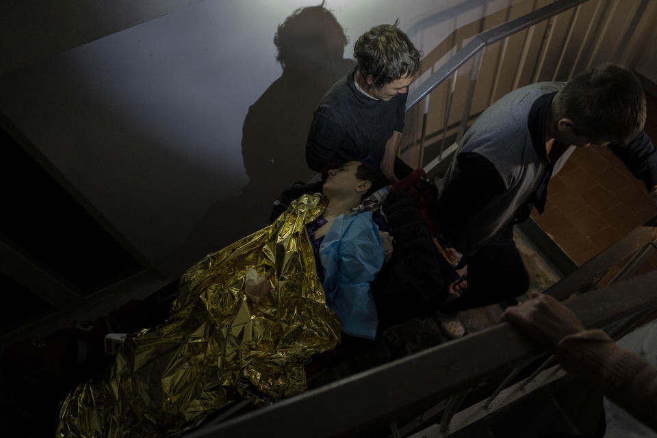 Staff carry 13-year-old Artur Voblikov on a stretcher up the stairs to the operating room inside a hospital in Kherson, southern Ukraine, Tuesday, Nov. 22, 2022. Arthur Voblikova was injured after a Russian strike, and doctors had to amputate his left arm. As attacks increase in the recently liberated city of Kherson, doctors are struggling to cope amid little water, electricity and a lack of equipment. (AP Photo/Bernat Armangue)