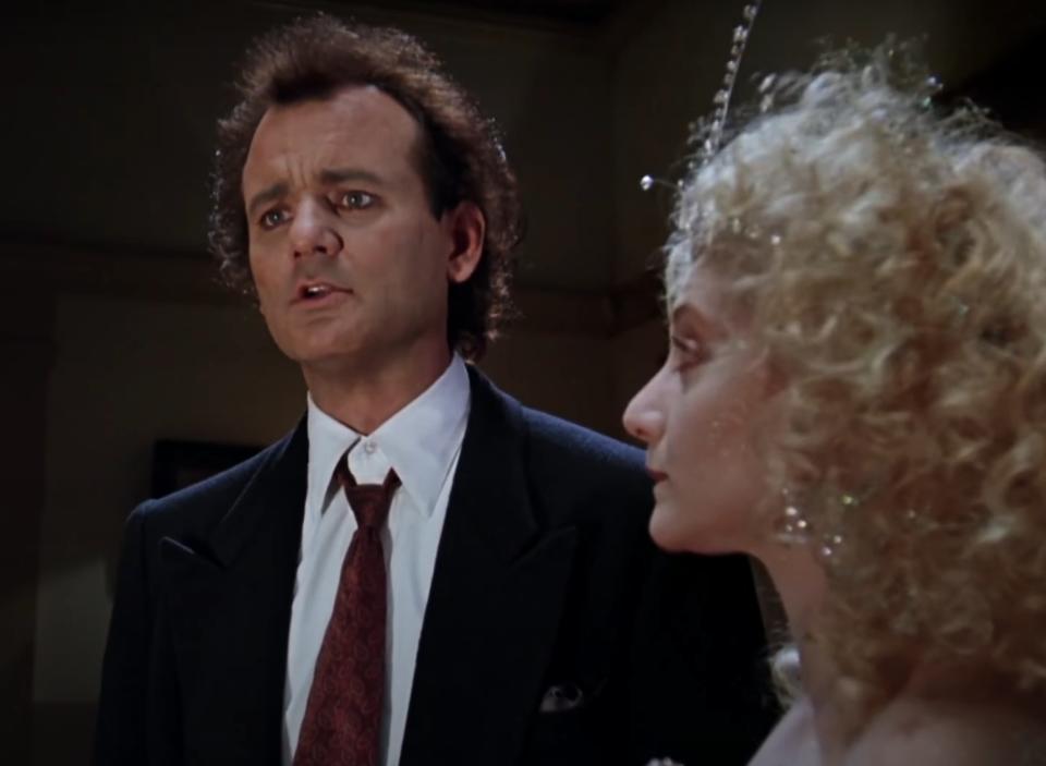 Bill Murray as Frank Cross and Carol Kane as the Ghost of Christmas Present appear in "Scrooged"