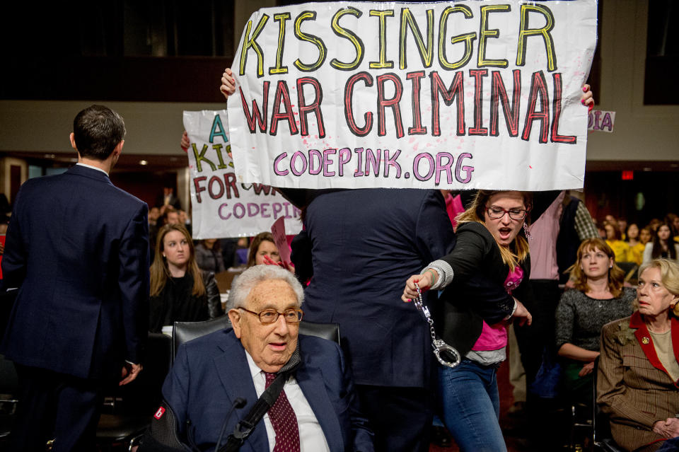 The protest group CodePink disrupts a Senate Armed Services Committee hearing, carrying banners calling former Secretary of State Henry Kissinger a "war criminal" as he and fellow former Secretary of States George Shultz and Madeleine Albright were set to testify on U.S. national security on Capitol Hill on Jan. 29, 2015.