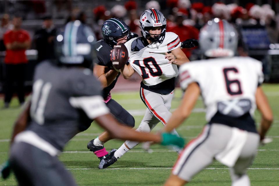 Tulsa Union quarterback Kason Delgado (10) tries to get away from Edmond Santa Fe's Bergin Kysar (1) during a high school football game at Wolves Stadium in Edmond, Okla., Friday, Oct. 6, 2023.