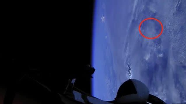 A UFO seen darting across the sky between the roadster and Earth.