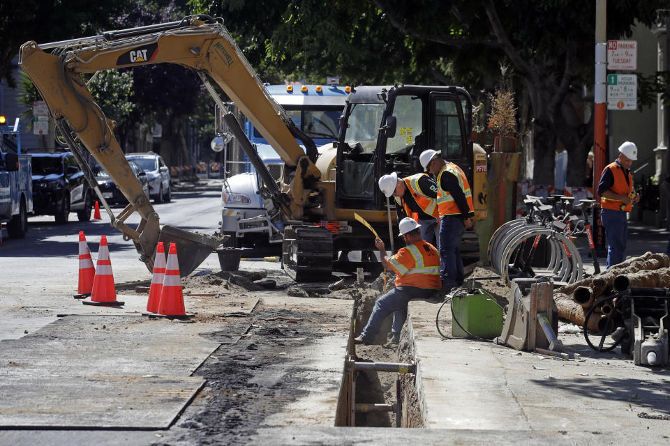 This Aug. 15, 2019 photo shows a Pacific Gas & Electric crew working in San Francisco. San Francisco officials are offering to buy Pacific Gas & Electric's power lines and other infrastructure in the city for $2.5 billion. Mayor London Breed and City Attorney Dennis Herrera presented the offer in a letter sent to the utility Friday, Sept. 6, 2019. (AP Photo/Jeff Chiu)