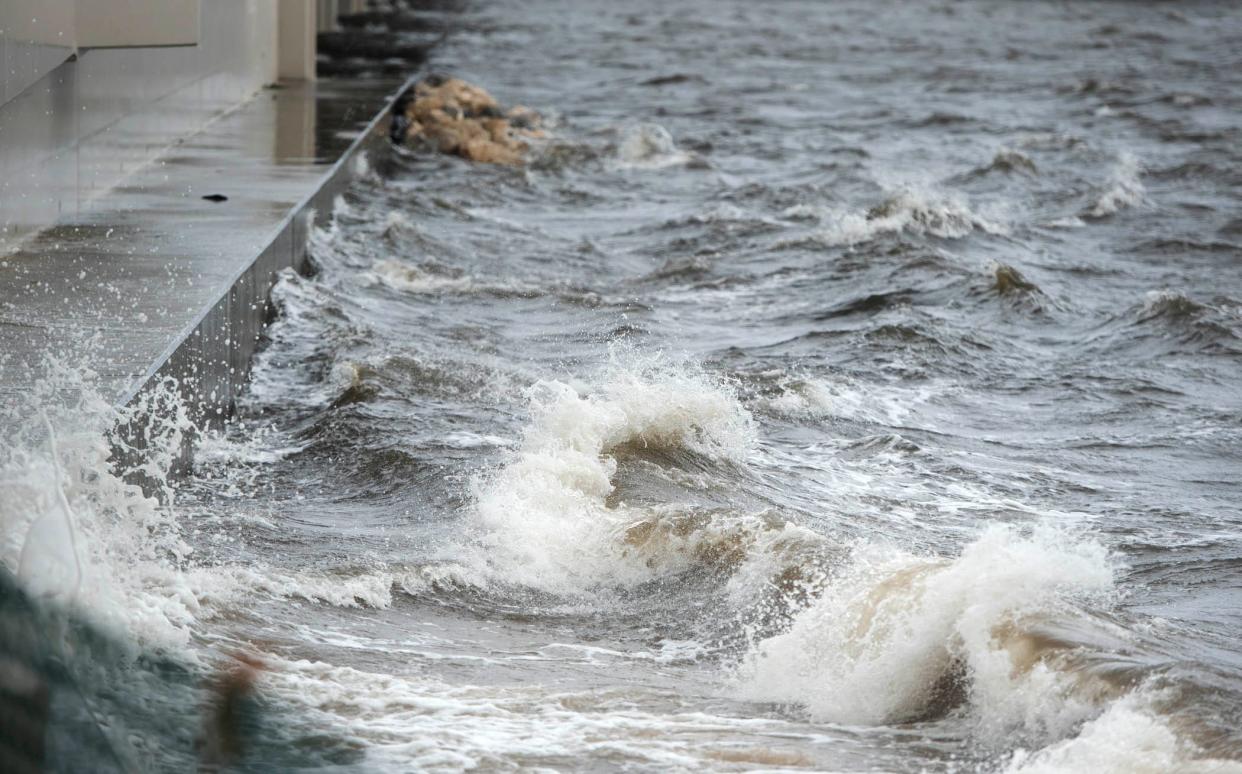 Waves crash against the small Southern Bridge as wind and rain from Hurricane Ian arrive September 28, 2022 in Palm Beach. 