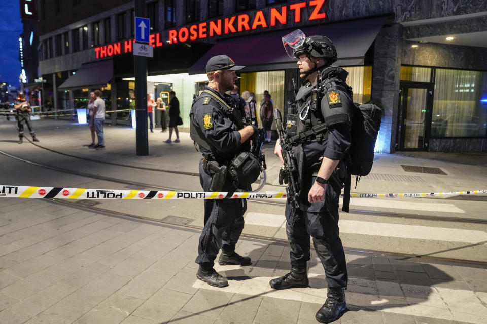 Dos policías vigilan el frente de un bar tras una balacera en el exterior que dejó dos muertos y más de una docena de heridos, el sábado 25 de junio de 2022, en el centro de Oslo, Noruega. (Javad Parsa/NTB vía AP)