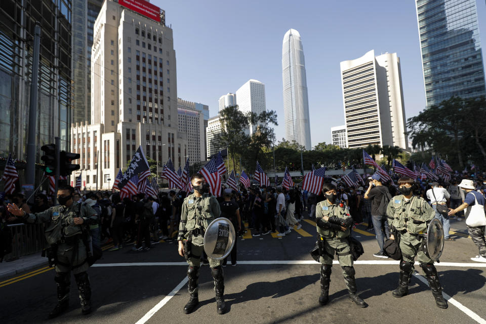Riot policemen stand watch as protesters march to U.S. Consulate during a rally in Hong Kong, Sunday, Dec. 1, 2019. Hong Kong protesters carrying American flags and banners appealing to President Donald Trump rallied in the semi-autonomous Chinese territory. (AP Photo/Vincent Thian)