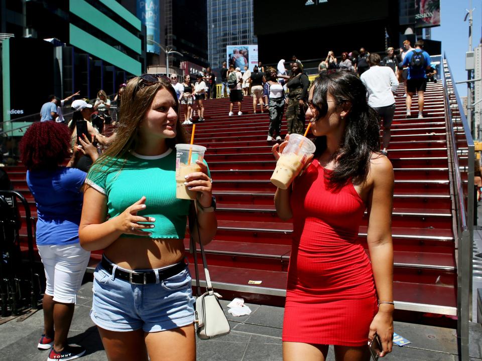 Women drink iced coffee in Times Square.