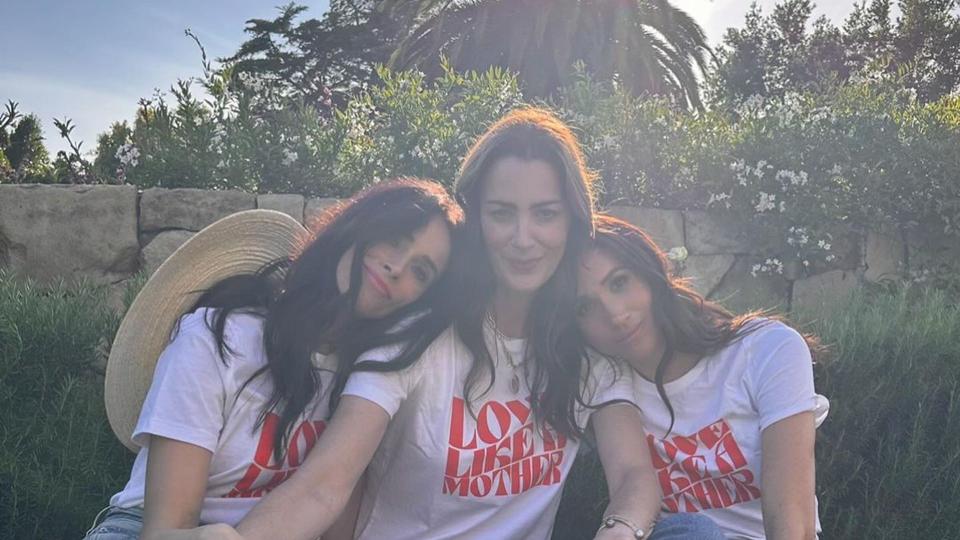 Meghan Markle sat with two women wearing a t-shirt saying 'love like a mother'