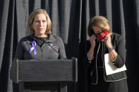 University of Utah President Ruth Watkins, right, puts on her mask as Jill McCluskey, the mother of slain University of Utah student-athlete Lauren McCluskey speaks during a press conference announcing they have reached a settlement in their lawsuit against the university Thursday, Oct. 22, 2020, in Salt Lake City. (AP Photo/Rick Bowmer)