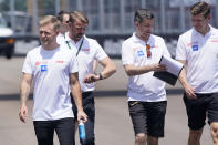 Haas driver Kevin Magnussen, left, of Denmark, walks the track with crew members as teams prepare for the Formula One Miami Grand Prix auto race at Miami International Autodrome, Thursday, May 5, 2022, in Miami Gardens, Fla. The race is Sunday, May 8. (AP Photo/Wilfredo Lee)