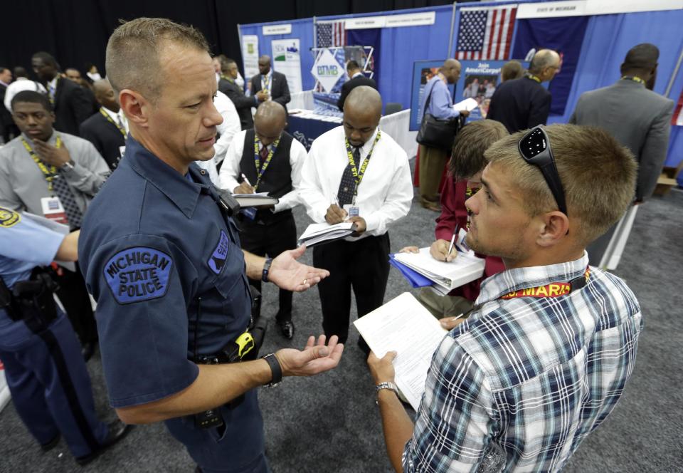 Michigan State Police Trooper Matt McCaul, left, talks with military veteran Christopher Honold, of Canton, Mich., in Detroit, Tuesday, June 26, 2012 . Thousands of veterans are in Detroit this week for job fair, open house, small business conference. (AP Photo/Paul SancyaT)