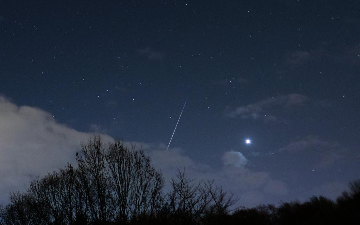 A meteor from the Geminid Meteor shower streaks across the night sky past Sirius in Saltburn By The Sea, United Kingdom